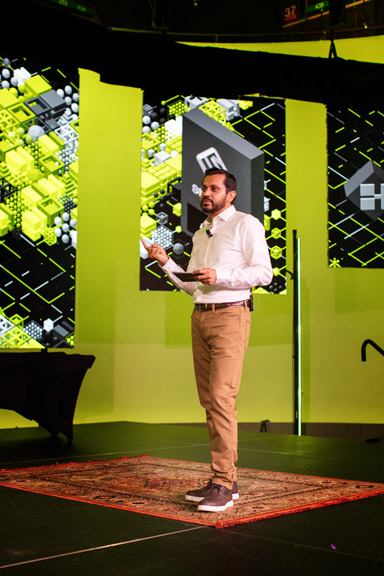 Contestant-Image-4 A contestant proposing an idea on-stage surrounded by large LED screens