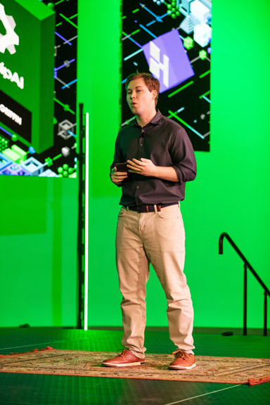 Contestant-Image-5 A contestant proposing an idea on-stage surrounded by large LED screens